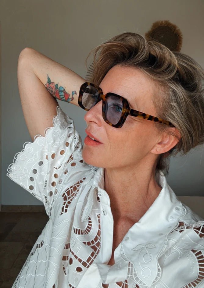 Model wearing Phlox sunglasses by AndBloom – matte tortoise frame with vibrant blue lenses, stylish eyewear for women 50+