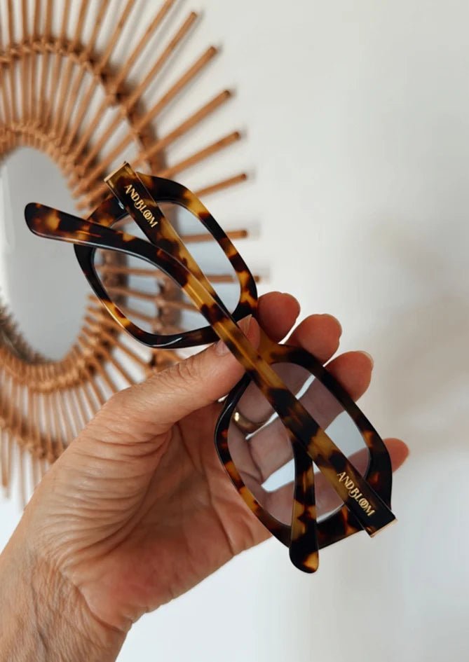 Hand holding Phlox sunglasses – premium tortoise frame with blue lenses by AndBloom, protective and stylish women’s eyewear