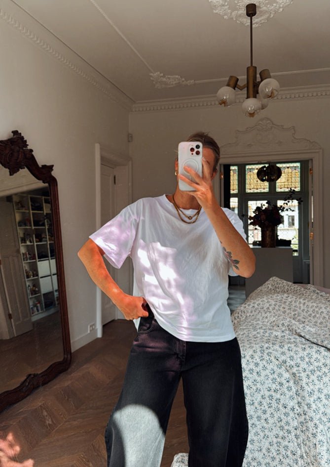 Model wearing The Classic White – AndBloom T-shirt styled casually indoors